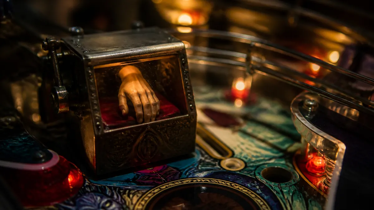 Détail du plateau du flipper Addams Family avec la boîte de la Chose et ses aimants